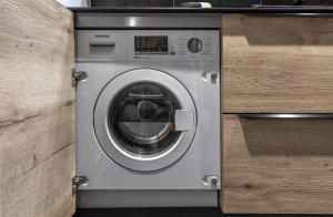 a washing machine sitting inside of a wooden cabinet at Cristal Des Alpes - Superb T3 - Vue Mont-Blanc in Les Houches