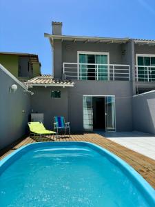 een zwembad op het terras van een huis bij Casa de Hóspedes com Piscina em Porto Belo in Porto Belo