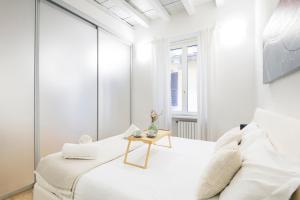 biała sypialnia z białym łóżkiem i stołem w obiekcie Amazing, new & fully furnished studio in Duomo w Mediolanie