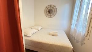 a small bedroom with a small bed with a mirror at Lafayette - Guyancourt in Guyancourt