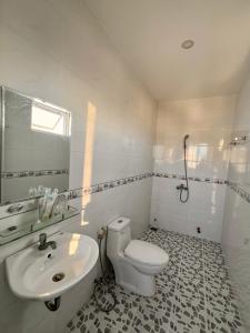 a white bathroom with a toilet and a sink at HT Phuong Thao Boutique in Nha Trang +9 photos