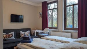 a living room with two beds and a couch at Pension Weseraue in Holzminden
