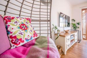 a bedroom with a bed with a pillow and a table at Sunset Garden Cottage, Reydon in Reydon +20 photos