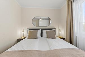 a bedroom with a large white bed with a mirror at Free Parking I Balcony I 5 min to Train Station in Vienna