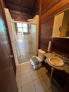 ein Badezimmer mit Dusche, Toilette und Waschbecken in der Unterkunft Residencial Alvorada in Bombinhas