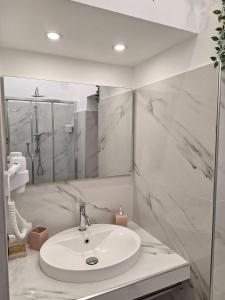 a white bathroom with a sink and a shower at Casa vacanze al teatro in Catania