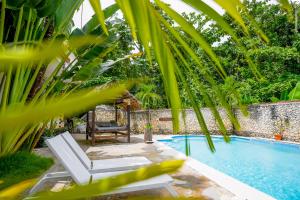 a swimming pool with a lounge chair at Casa Estrellas Mirabal in Sosúa