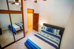 a bedroom with a bed and a mirror and a bed at Casa Estrellas Mirabal in Sosúa