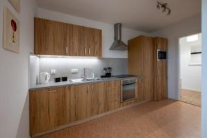 a kitchen with wooden cabinets and a sink at Apartament Miodowy in Powidz