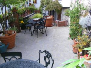 a patio with tables and chairs and potted plants at Casa Marchi in Bagni di Lucca