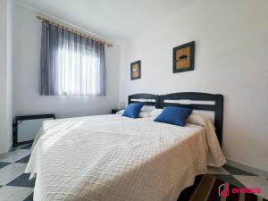 a bedroom with a large bed with blue pillows at La Marina in Oropesa del Mar