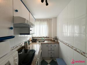 a white kitchen with a sink and a counter top at La Marina in Oropesa del Mar