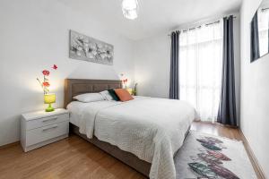 ein weißes Schlafzimmer mit einem Bett und einem Fenster in der Unterkunft Villa Nick in Cavtat