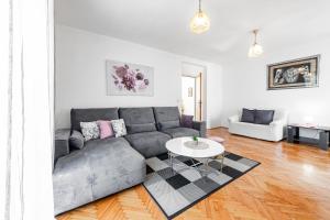 ein Wohnzimmer mit einer grauen Couch und einem Tisch in der Unterkunft Villa Nick in Cavtat