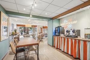 a restaurant with a table and chairs and a counter at Surf Club Hôtel by Akena - Grande plage in Biarritz