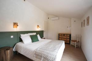 een slaapkamer met een groen en wit bed en een dressoir bij Bed & Breakfast Perbos 1556 in Labastide-Clairence