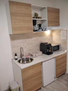 a small kitchen with a sink and a microwave at EszE Vendégszoba in Tata +3 photos