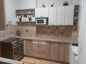 a kitchen with a counter top with a microwave at Adél Apartman in Kaposvár