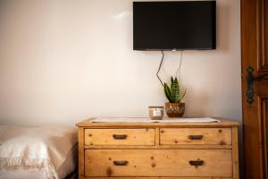a bedroom with a dresser with a tv on the wall at Masito Apartments The Hub in Cortina dʼAmpezzo +28 photos