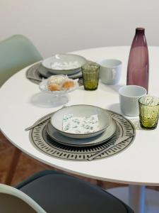 a white table with plates and cups on it at Casa Magenta Holiday in Galatro +8 photos