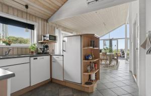 a kitchen with a refrigerator and a table at Stunning Home In Vestervig With Sauna in Vestervig