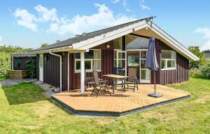 una casa con una mesa y sillas en una terraza en Holiday Home Pøt Strandby Denk Vi, en Sønderby
