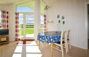 Un comedor con mesa y sillas y un televisor. en Holiday Home Pøt Strandby Denk Vi, en Sønderby