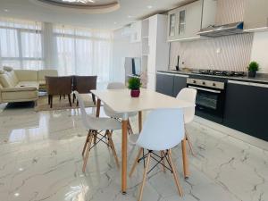 a kitchen and living room with a white table and chairs at CHEZ EL HADJI NGOR in Dakar