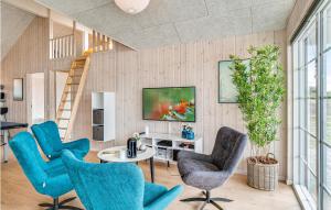 un soggiorno con tavolo e sedie blu di Cozy Home In Nørre Nebel With Sauna a Nørre Nebel