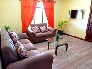 a living room with two couches and a coffee table at Villa Ceiba in Fortuna