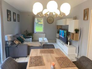 Saint-Rémy-en-RollatMaison proche de vichy的客厅里有一张沙发和一张桌子。