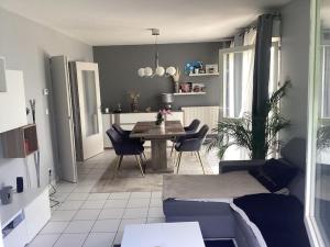 a living room with a couch and a table and chairs at Maison proche de vichy in Saint-Rémy-en-Rollat