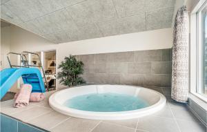 un bagno con ampia vasca e finestra di Cozy Home In Nørre Nebel With Sauna a Nørre Nebel Altre 23 foto