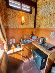 a small kitchen with a sink and a stove at Joglo Homestay Banyuwangi in Banyuwangi