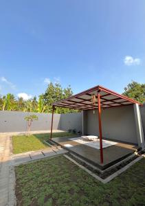 a pavilion with a roof in a yard at Joglo Homestay Banyuwangi in Banyuwangi
