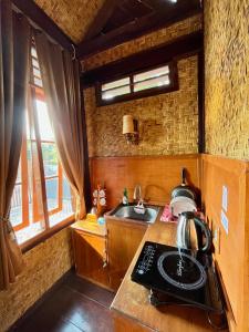 a small kitchen with a stove and a sink at Joglo Homestay Banyuwangi in Banyuwangi