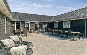un patio con tavoli e sedie su un edificio di Amazing Home In Nørre Nebel With Wifi a Nørre Nebel Altre 20 foto