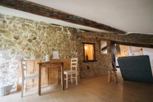 a room with a stone wall with a table and chairs at Bed & Breakfast Perbos 1556 in Labastide-Clairence