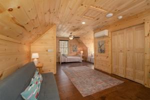 un salon en rondins avec un canapé et une chambre dans l'établissement El Escorpio North, à Brevard