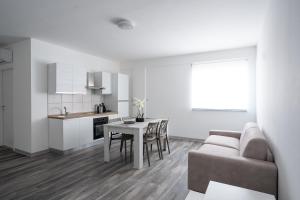 a kitchen and a living room with a table and a couch at Capri Residence in Casoria +49 photos