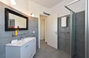 un bagno con lavandino, specchio e doccia di Aspro Villas a Piso Livadi Altre 72 foto