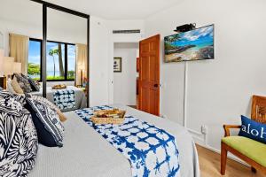 a bedroom with a bed and a tv on the wall at Kaanapali Shores 104 in Kahana +27 photos