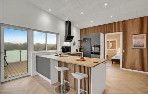 a kitchen with a island with bar stools at Beautiful Home In Spøttrup With Wifi in Lihme +30 photos