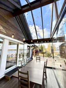 a dining room with a table and chairs and windows at Rantavilla 7 hlo poreallas in Jämsä +5 photos