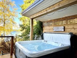 a hot tub on a deck with a view of the water at Rantavilla 7 hlo poreallas in Jämsä