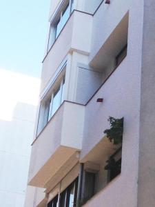 a tall white building with windows on the side of it at Linda Appartamento Lloret in Lloret de Mar