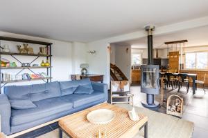 a living room with a blue couch and a table at Les 5 Vallées - Appt en Duplex avec vue montagne in Briançon +7 photos