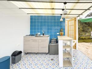 a kitchen with a sink and a blue tile wall at Rancho Las Santas in Guasca