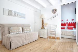 a white bedroom with a bed and a mirror at Les balcons des Ecréhous - Duplex front de mer in Saint-Jean-de-la-Rivière