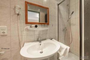 a bathroom with a sink and a shower with a mirror at Café Pension Leistner in Obertrubach
